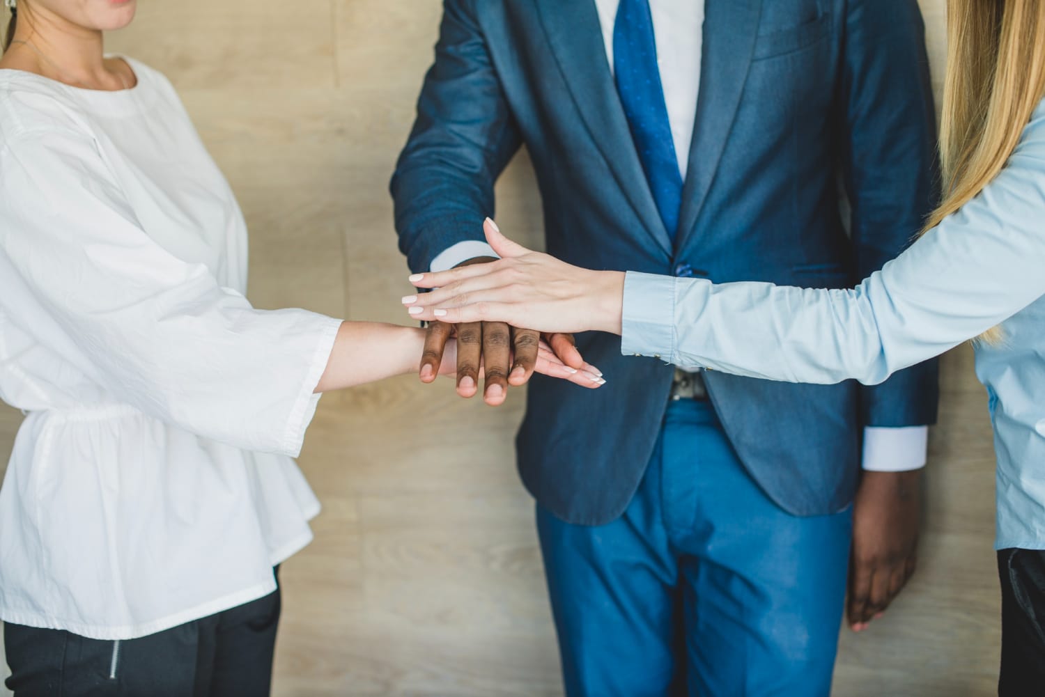 أيدٍ متشابكة لشركاء يبدؤون تأسيس شركة في السعودية